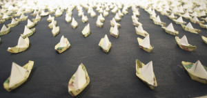 Origami boats on painted canvas